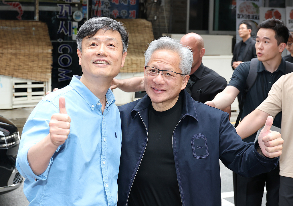 Jensen Huang and KRAFTON Executive Chairman Chang Byung-gyu pose in front of an internet cafe in Seoul, South Korea, on June 7, 2026